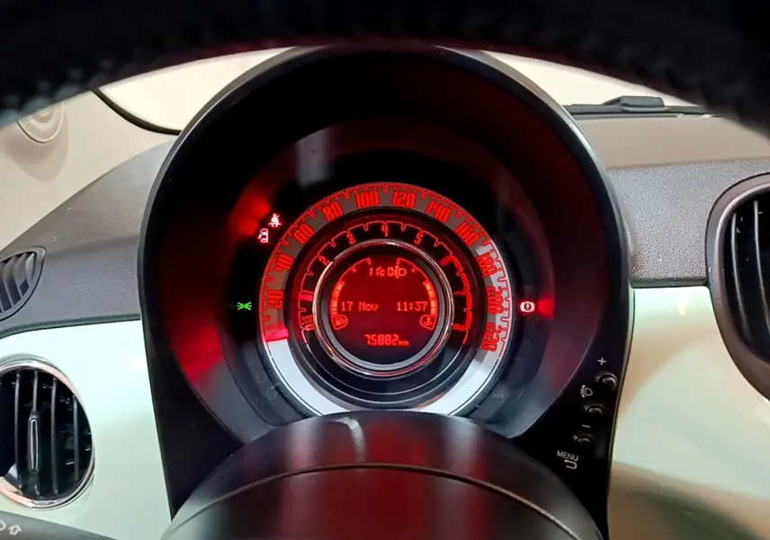 Vue rapprochée du tableau de bord numérique rouge de la Fiat 500 verte, affichant la vitesse et le kilométrage.