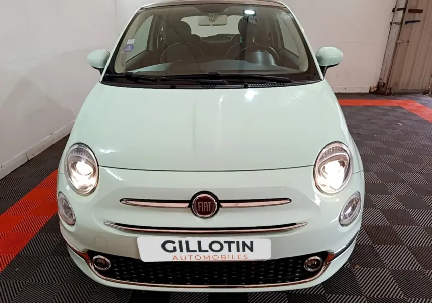 Vue avant d'une Fiat 500 Lounge 2019 vert clair avec phares allumés dans un garage.