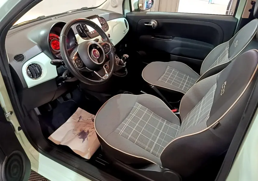 Vue intérieure côté conducteur de la FIAT 500 Lounge 2019 avec sièges gris à motifs et tableau de bord clair.
