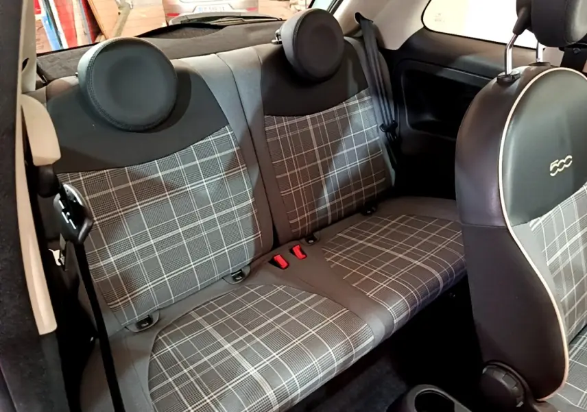 Vue intérieure du siège arrière et dossier à motif écossais gris de la Fiat 500 Lounge 2019, avec appuie-têtes ronds noirs.