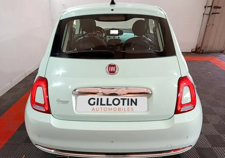 Vue arrière d'une FIAT 500 Lounge 2019 vert clair avec feux arrière rouges et logo Fiat visible.