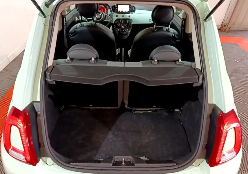 Coffre ouvert vu de l'arrière d'une FIAT 500 Lounge 2019 vert clair, montrant l'habitacle et la tablette de séparation.