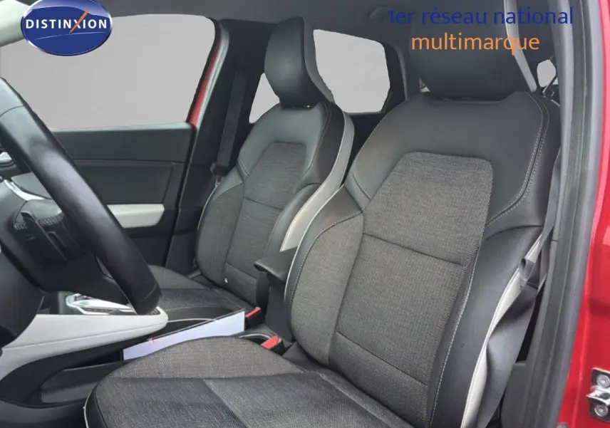 Vue intérieure côté avant droit du Renault Captur rouge flamme, mettant en valeur les sièges bi-matière gris et noir.