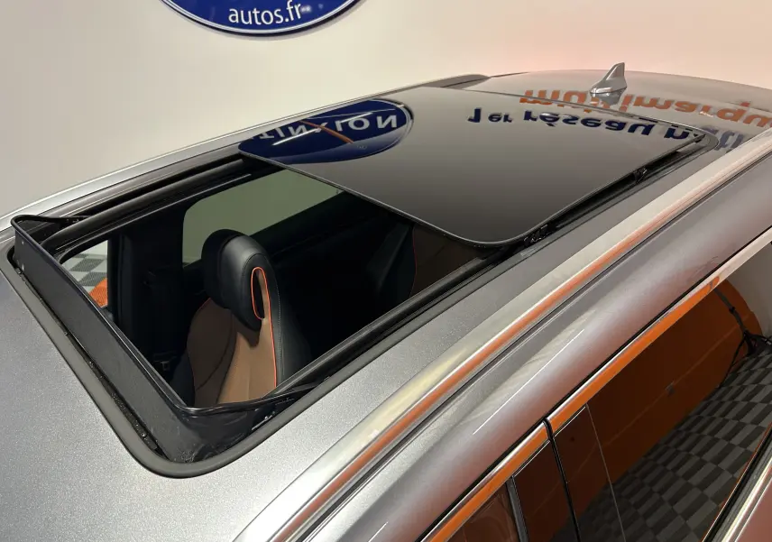 Vue en plongée du toit ouvrant ouvert sur BYD SEAL U gris métallisé avec intérieur cuir marron et surpiqûres orange.