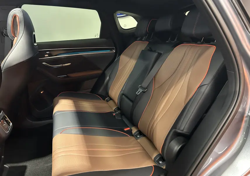 Vue intérieure côté droit des sièges arrière en cuir marron et noir avec surpiqûres orange du BYD SEAL U 2025.