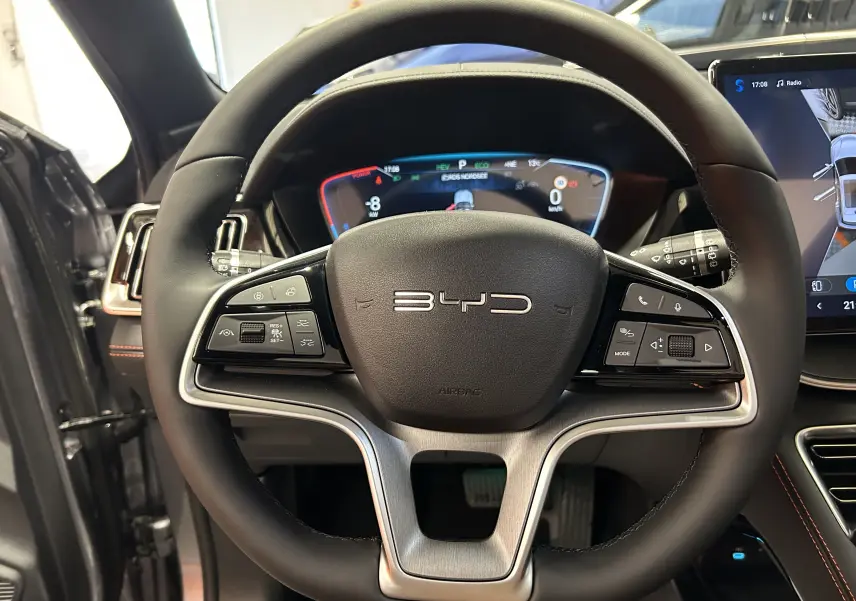 Vue rapprochée du volant noir du BYD SEAL U 2025 avec tableau de bord numérique et écran tactile latéral.
