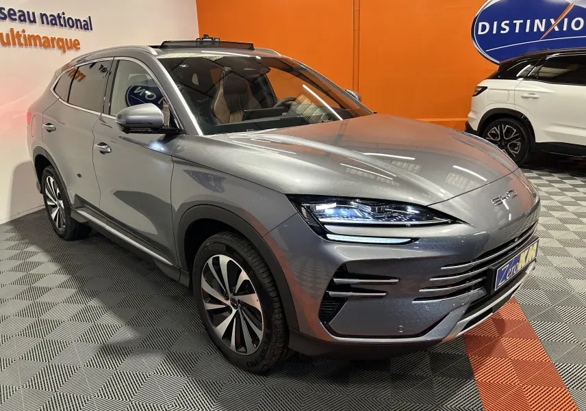 Vue 3/4 avant droite du SUV BYD SEAL U gris métallisé avec phares LED allumés dans un showroom.