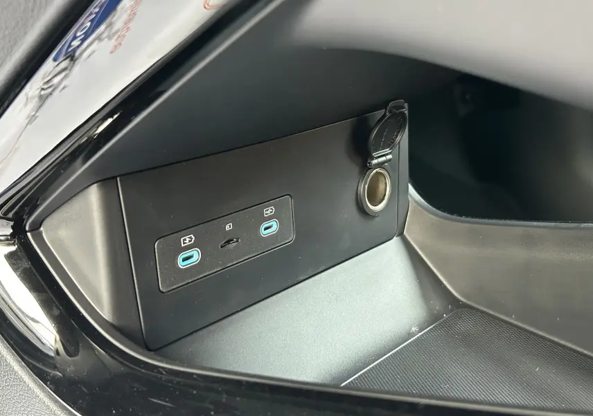 Gros plan sur la console intérieure noire du BYD SEAL U avec deux ports USB-C et une prise 12V ouverte.