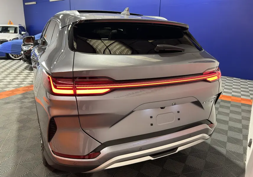 Vue 3/4 arrière droite du BYD SEAL U gris métallisé avec feux arrière allumés dans un showroom.