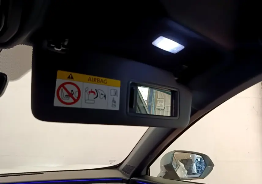 Intérieur du CUPRA Formentor 2023, vue côté passager avec pare-soleil ouvert et éclairage d'ambiance bleu visible.