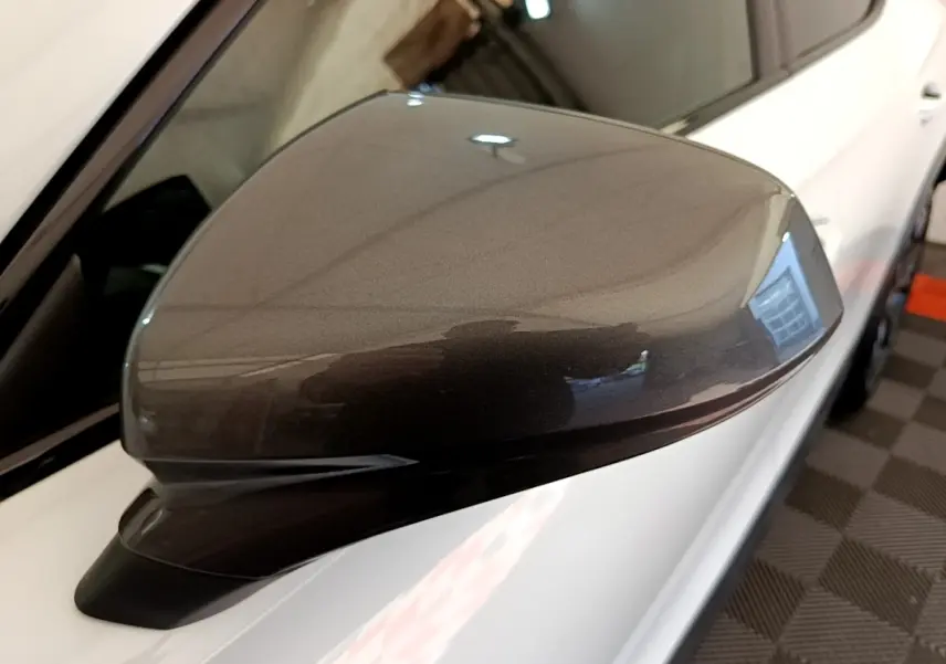 Rétroviseur droit gris métallisé du CUPRA Formentor 2023, avec carrosserie blanche visible en arrière-plan.