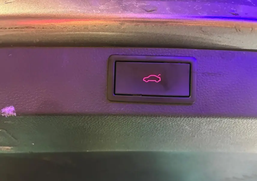 Bouton d'ouverture électrique du hayon sur le panneau intérieur d'un Skoda Karoq gris 2023.