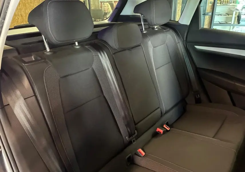 Vue intérieure des sièges arrière noirs de la Skoda Karoq 2023, avec appuie-têtes et ceintures de sécurité visibles.