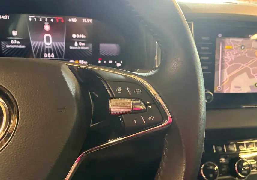 Gros plan sur le volant multifonctions cuir du Skoda Karoq 2.0 TDI 116 DSG7 Business avec tableau de bord numérique et écran tactile.