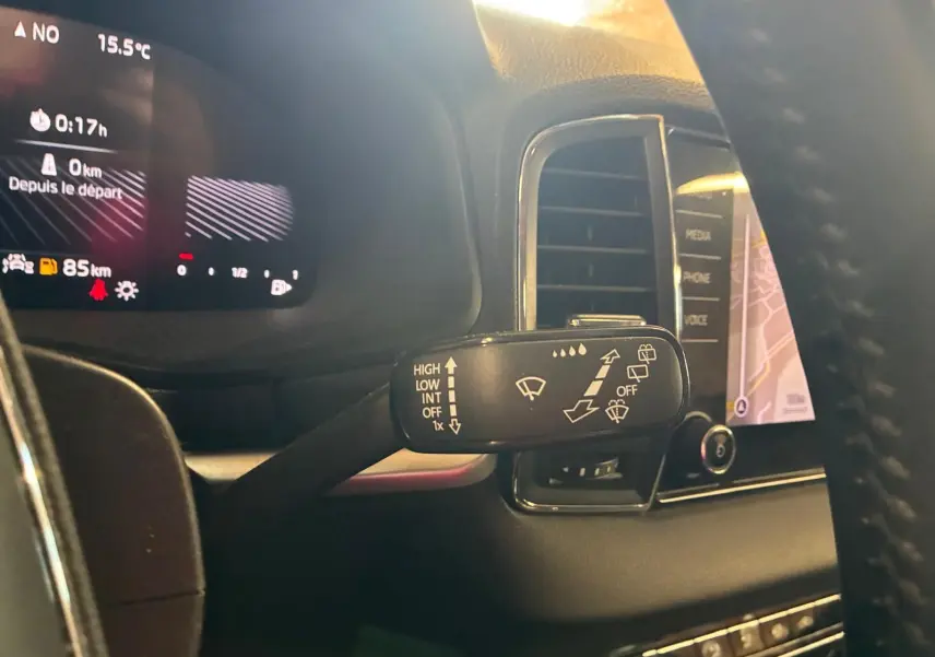 Gros plan sur la commande des essuie-glaces à gauche du volant dans l’habitacle gris du Skoda Karoq 2023.