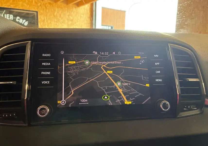 Écran tactile multimédia du Skoda Karoq gris 2023 affichant la navigation avec carte et options latérales.