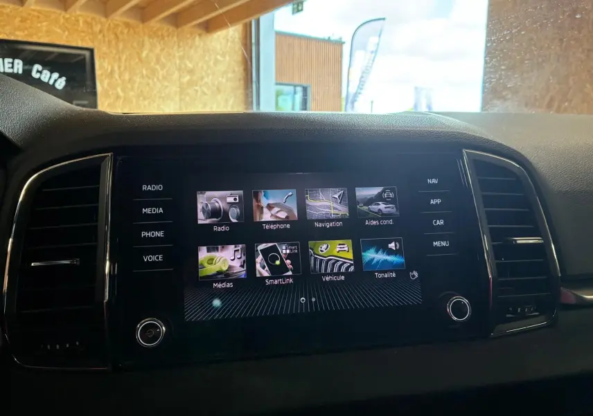 Écran tactile multimédia central du Skoda Karoq 2023 avec menus navigation, téléphone et SmartLink visibles.