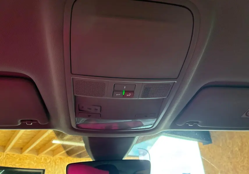 Vue intérieure du plafonnier avant du Skoda Karoq gris 2023, avec commandes d'éclairage et bouton SOS visible.