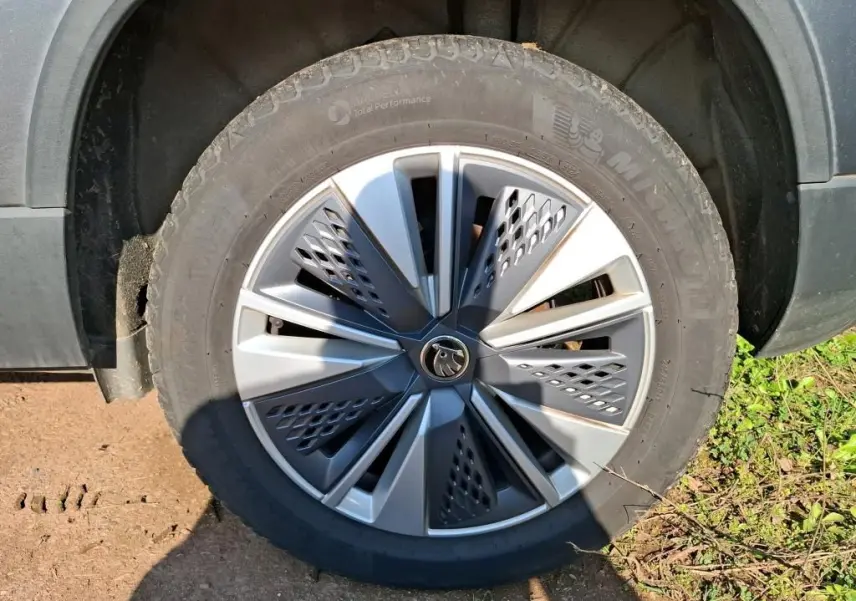 Gros plan sur la jante alu 17 pouces gris argent avec logo Skoda, montée sur un pneu Michelin d’un Skoda Karoq gris.