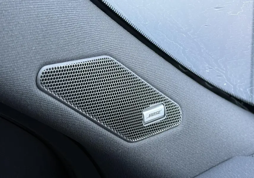 Gros plan sur l'enceinte Bose intégrée dans l'habitacle noir du Nissan Qashqai 2025.