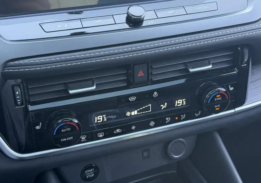 Vue rapprochée de la console centrale du Nissan Qashqai 2025, affichage de la climatisation automatique bi-zone.