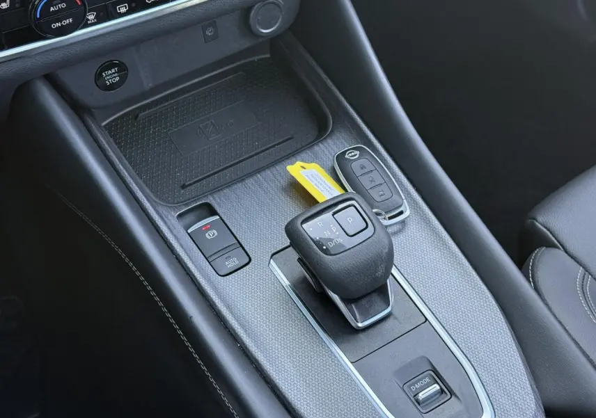 Vue rapprochée de la console centrale noire du Nissan Qashqai 2025 avec levier de vitesse automatique et clé électronique.
