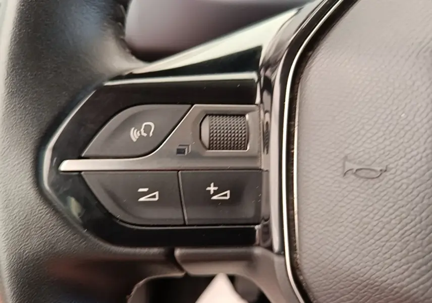 Gros plan sur les commandes multifonctions du volant cuir noir du Peugeot Rifter blanc, version 2020.
