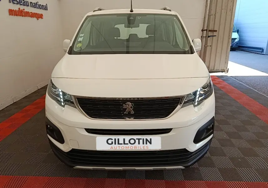 Vue avant d'un Peugeot Rifter blanc 2020 avec calandre noire et feux LED allumés en intérieur.