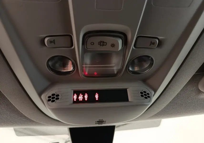 Vue intérieure du plafonnier du Peugeot Rifter blanc 2020 avec commandes d’éclairage et indicateurs de ceinture allumés.