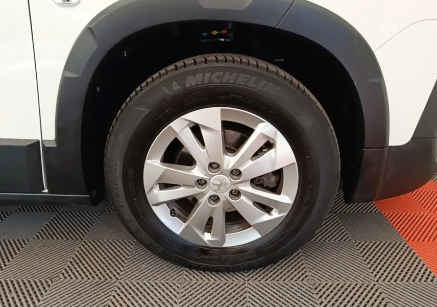 Gros plan sur la roue avant droite d’un Peugeot Rifter blanc avec jante alliage et pneus Michelin.