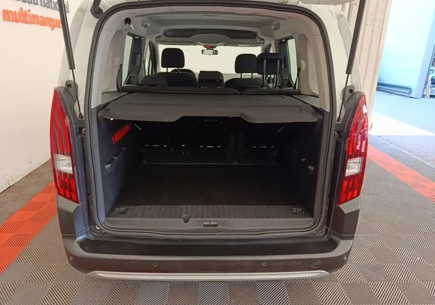 Vue arrière du coffre ouvert du Peugeot Rifter blanc 2020, montrant l'espace de chargement et la banquette arrière.
