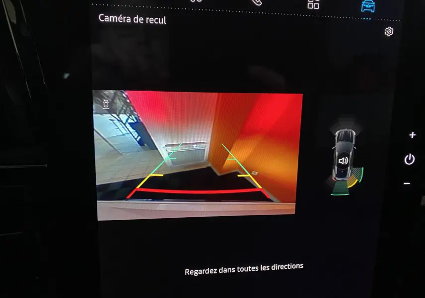 Affichage de la caméra de recul du Renault Austral blanc nacré, montrant un mur orange et le sol en carrelage.