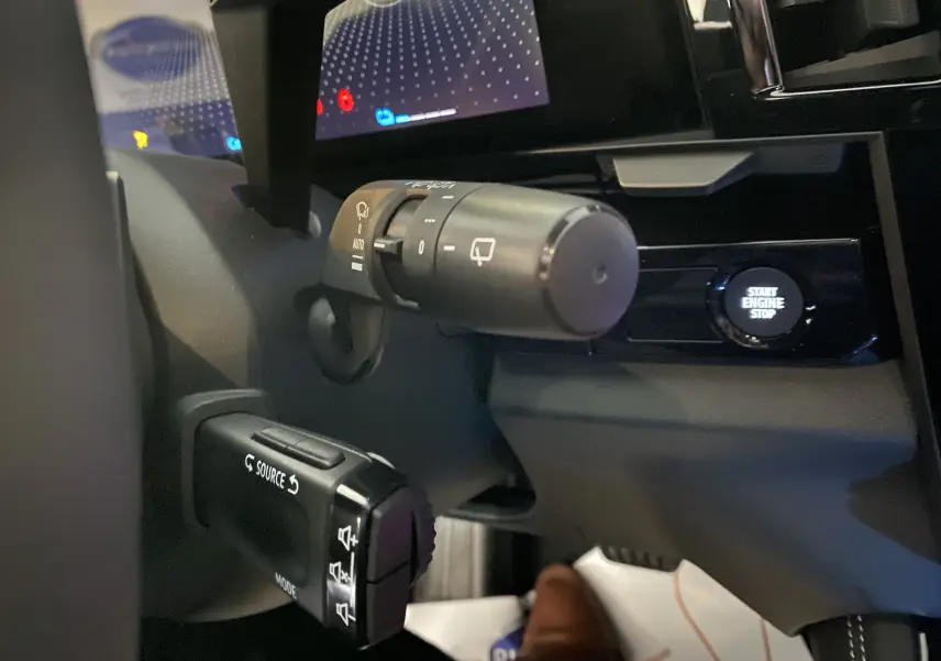 Gros plan sur la commande multifonction et le bouton start du tableau de bord du Renault Austral blanc nacré 2023.