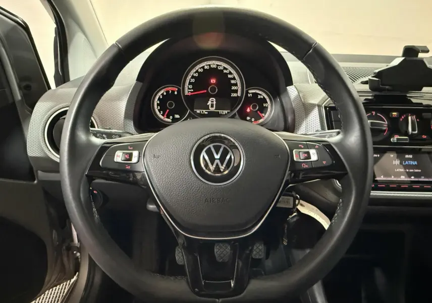 Vue intérieure centrée sur le volant cuir noir et le tableau de bord du Volkswagen Up 1.0 65 Active 2022.