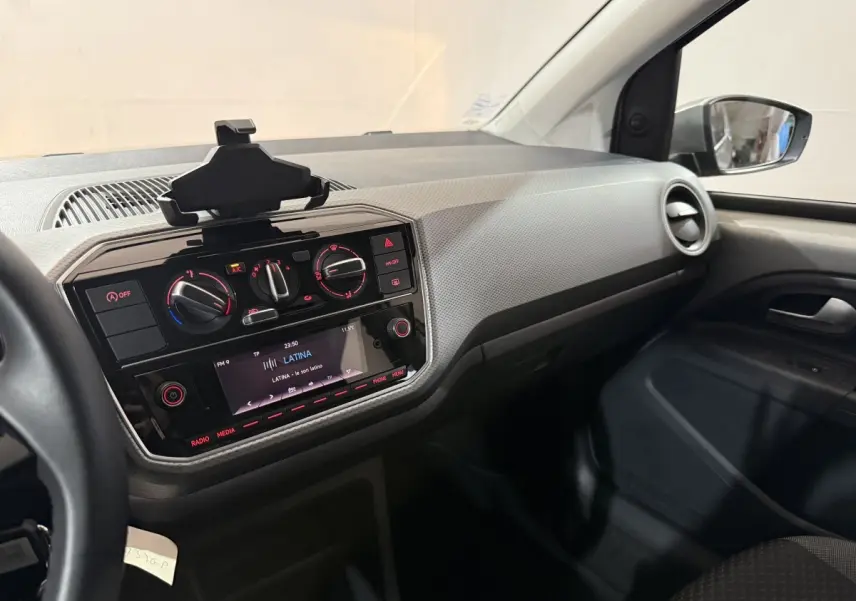 Intérieur de Volkswagen Up 1.0 65 Active 2022, vue côté passager sur tableau de bord et console centrale noire.