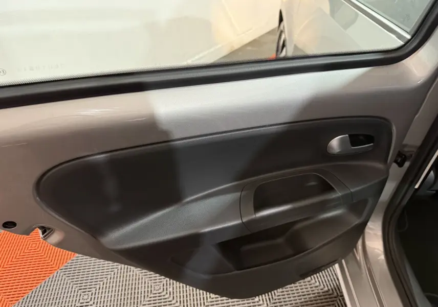 Porte arrière côté droit ouverte d'une Volkswagen Up gris foncé, montrant la garniture intérieure noire simple.