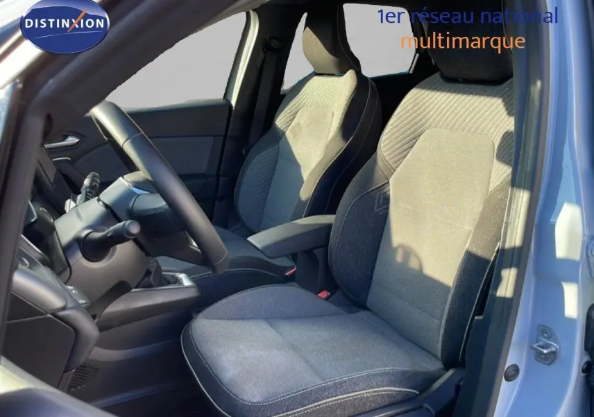 Vue intérieure côté conducteur du Renault Captur gris Rafale métal, montrant les sièges en tissu gris et le volant.