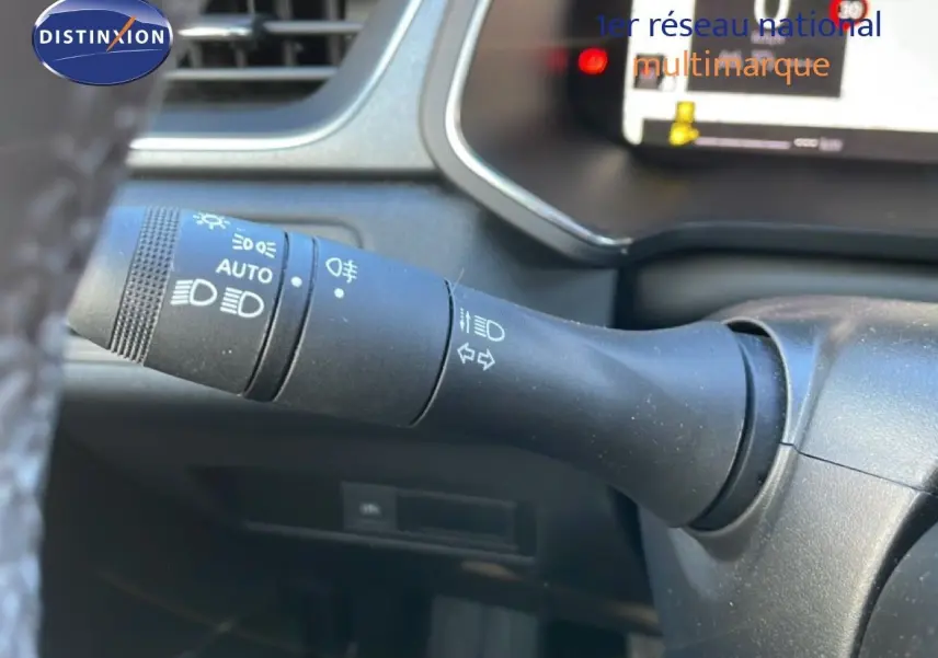 Gros plan sur la commande des feux à gauche du volant dans l’habitacle gris noir du Renault Captur 2025 bicarburation.