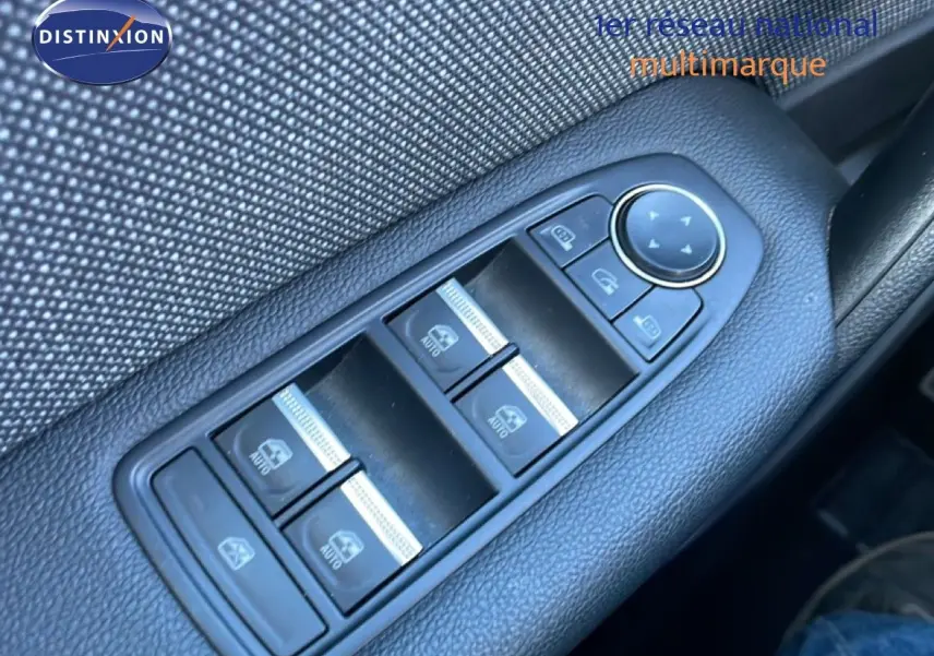 Gros plan sur les commandes des vitres électriques côté conducteur du Renault Captur gris Rafale métal avec toit noir.