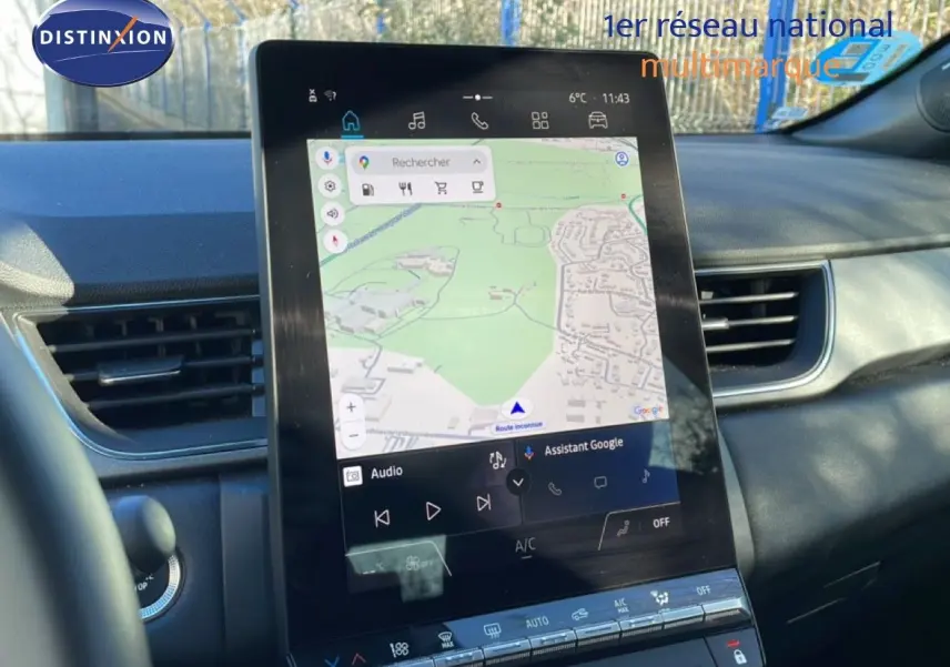 Vue intérieure centrée sur l'écran tactile vertical du tableau de bord du Renault Captur gris rafale métal avec toit noir.
