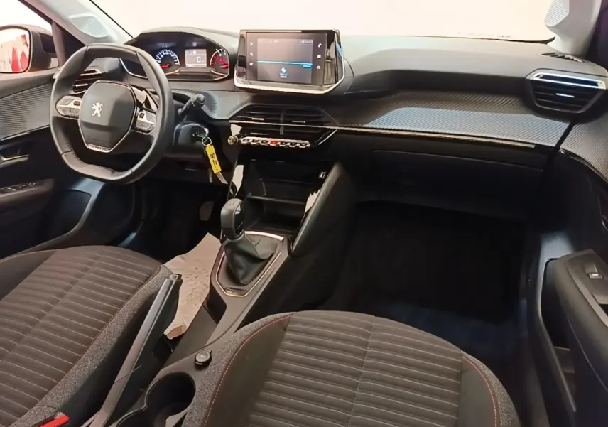 Intérieur de la Peugeot 208 PureTech 75 S&S Active Pack 2023, vue avant centrée sur tableau de bord et volant cuir multifonctions.