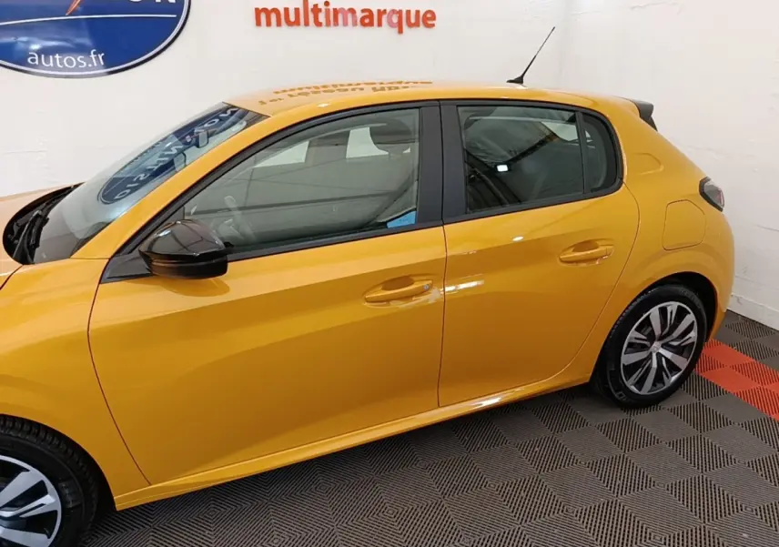 Profil droit d'une Peugeot 208 jaune 2023 avec rétroviseurs noirs et jantes bicolores dans un showroom.