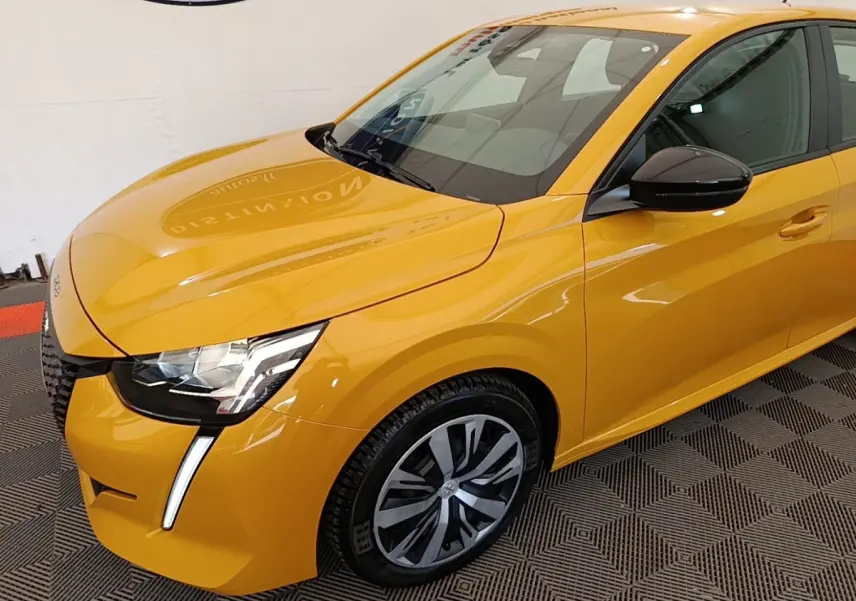 Vue 3/4 avant droite d'une Peugeot 208 jaune vif avec phares à LED et rétroviseurs noirs brillants.