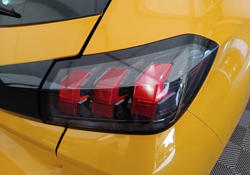Gros plan sur le feu arrière droit rouge de la Peugeot 208 jaune PureTech 75 S&S Active Pack 2023.