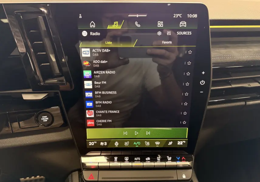Écran tactile central du Renault Austral 2026 avec interface radio et commandes climatisation, intérieur noir avec touches chromées.