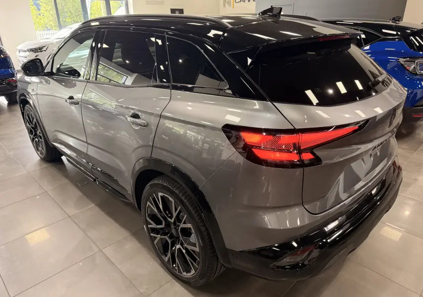 Vue 3/4 arrière droite du Renault Austral full hybrid gris schiste avec toit noir et jantes noires en concession.