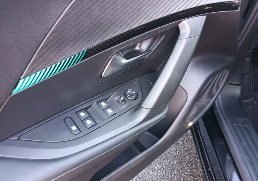 Détail de la porte côté conducteur du Peugeot 2008 noir 2022, montrant les commandes des vitres et la poignée intérieure.