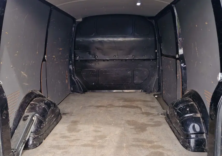 Vue intérieure arrière du coffre spacieux et noir du Volkswagen Transporter 2.0 TDi 150 ch L1H1 Business Line 2020.