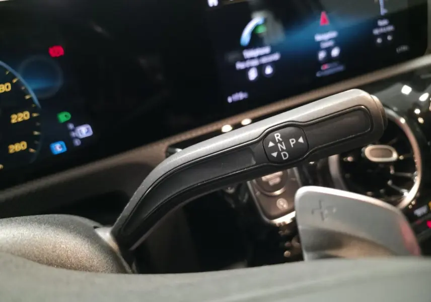 Gros plan sur la commande de boîte automatique à droite du volant dans le cockpit noir du Mercedes Classe A gris AMG Line 2019.