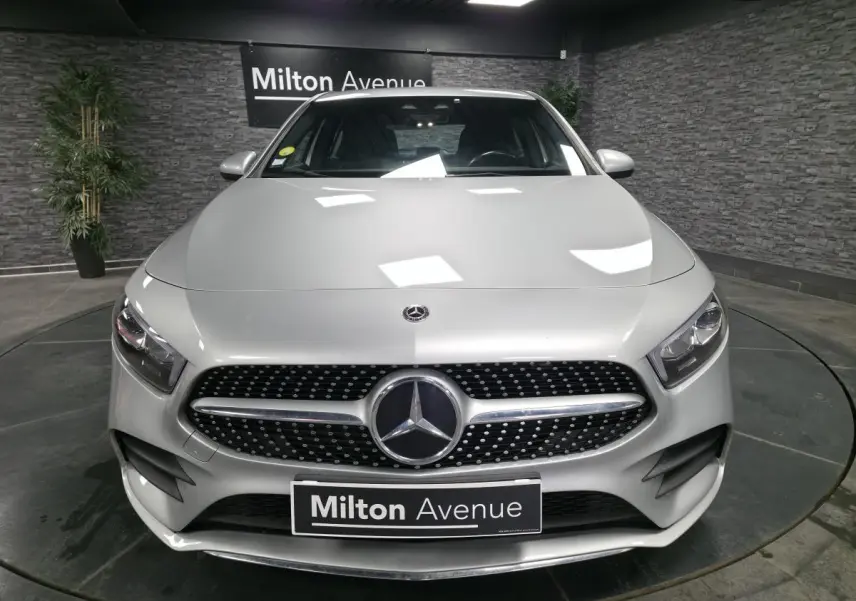 Vue frontale d'une Mercedes Classe A 200 d AMG Line gris métallisé avec calandre diamant et logo central lumineux.